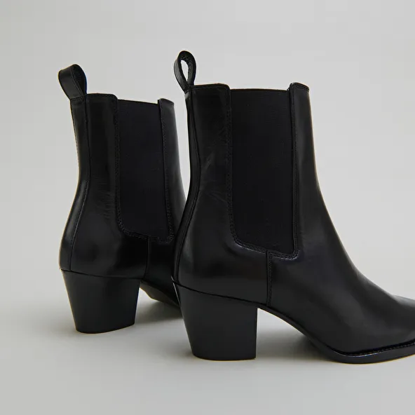 Ankle boots with beveled heels and pointed toes in black leather